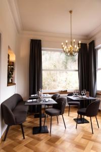 une salle à manger avec des tables et des chaises noires et une fenêtre dans l'établissement OSCARS Hotel 1415, à Bad Liebenzell