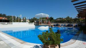 a large swimming pool with an umbrella on top of it at Hotel Marvel in Arillas