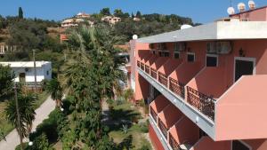 an apartment building with a palm tree next to a building at Hotel Marvel in Arillas