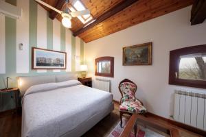 1 dormitorio con 1 cama y 1 silla en Agriturismo Santa Barbara, en Mira