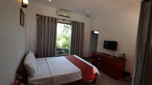 une chambre d'hôtel avec un lit et une fenêtre dans l'établissement HỒNG BIN RESORT, à Duong Dong