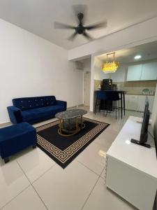 a living room with a blue couch and a table at Premium Service Appartment in Seri Kembangan