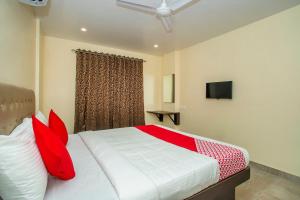 a bedroom with a bed with red pillows and a window at Super OYO Flagship Olivia Comforts Near Nexus Mall Koramangala in Bangalore