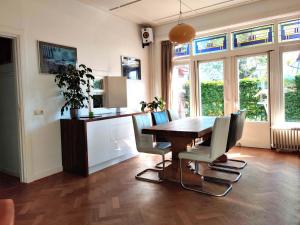 a dining room with a wooden table and chairs at Ecolodge Directorsroom and Swimmingpool in Tilburg