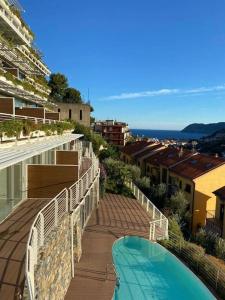 a balcony of a building with a swimming pool at Exclusive Apartment Alassio with sea view in Alassio
