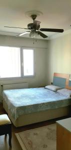 a bedroom with a large bed with a ceiling fan at Apartman dairesi in Balcova