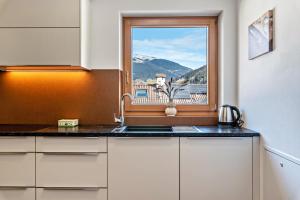 eine Küche mit einem Waschbecken und ein Fenster mit Aussicht in der Unterkunft Trojer Apartment 3 in Sarntal