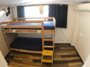 une chambre avec deux lits superposés et une échelle dans l'établissement Guest House Matsu, à Osaka 45 autres photos