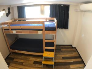 a room with two bunk beds and a ladder at Guest House Matsu in Osaka