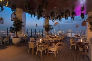 ein Restaurant mit Tischen und Stühlen und Stadtblick in der Unterkunft SLS Dubai Hotel & Residences in Dubai