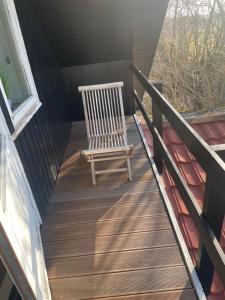 un fauteuil à bascule assis sur une terrasse en bois dans l'établissement Ledvogterhuset B&B, à Faxe