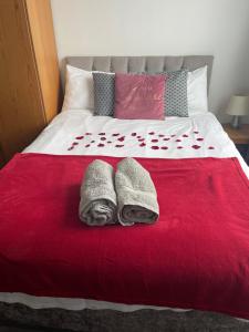 uma cama com duas toalhas num cobertor vermelho em Modern Studio with Free Parking near sea-station-shops em Portslade