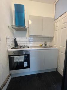 a small kitchen with a stove and a sink at Modern Studio with Free Parking near sea-station-shops in Portslade