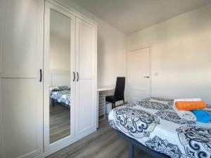 ein Schlafzimmer mit einem Bett, einem Schrank und einem Schreibtisch in der Unterkunft 7º Piso Traviesas Plaza América Próximo Playa in Vigo