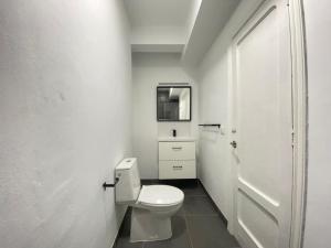 ein weißes Bad mit WC und Tür in der Unterkunft 7º Piso Traviesas Plaza América Próximo Playa in Vigo