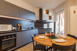 a kitchen with a wooden table with chairs and a dining room at [Luxury apartment near Navigli] - Anemoni 5 in Milan