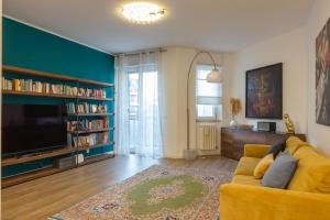 a living room with a yellow couch and a tv at [Luxury apartment near Navigli] - Anemoni 5 in Milan