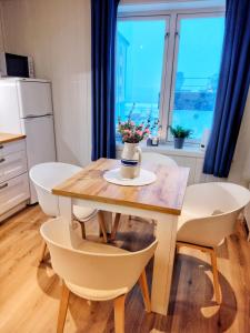 a kitchen with a table with a vase of flowers on it at Light home apartment Alesund with free parking in Ålesund