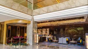 a lobby with tables and chairs in a building at Juntai Hotel Xiamen in Xiamen