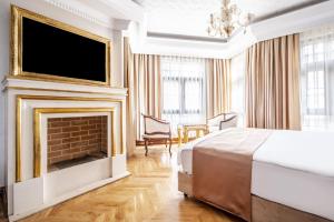 um quarto com uma lareira, uma cama e uma televisão em Superb Studio in Historic Mansion in Beylerbeyi em Istambul
