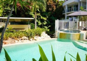 una piscina di fronte a un edificio con un resort di Tropical Luxe Apartment a Townsville