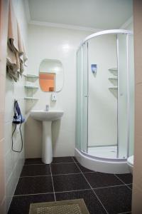 uma casa de banho com um chuveiro e um lavatório. em Alpinist Hotel em Bishkek