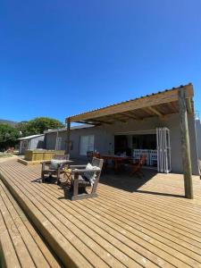 a wooden deck with a picnic table and a house at Living The Breede-Lorigan House in Malgas