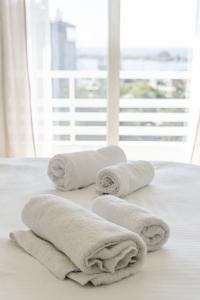 a group of towels sitting on top of a bed at Modern apt in Glyfada a Breath Away from the Sea - The View in Athens