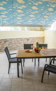 - une table avec un bol de fruits et des verres à vin dans l'établissement Iliopetra Apartment, à Naxos Chora