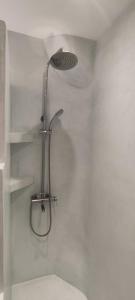 La salle de bains est pourvue d'une douche avec un pommeau de douche. dans l'établissement Iliopetra Apartment, à Naxos Chora