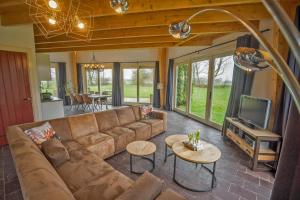 sala de estar con sofá y TV en Vacation house Hooihuys, en Woerden