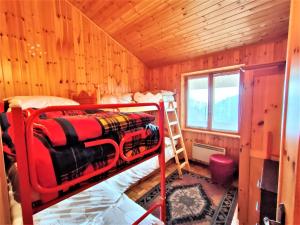 ein Schlafzimmer mit einem Etagenbett in einer Holzhütte in der Unterkunft Maison Elios 2 CIR-TORGNON-0005 in Torgnon