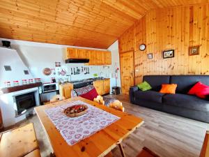 ein Wohnzimmer mit einem Tisch und einem Sofa in der Unterkunft Maison Elios 2 CIR-TORGNON-0005 in Torgnon