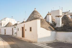 uma fila de edifícios brancos com telhados pontiagudos em Trulli di Zia Vittoria em Alberobello