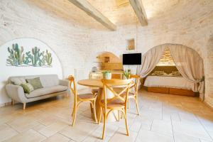 sala de estar con mesa y cama en Trulli di Zia Vittoria en Alberobello