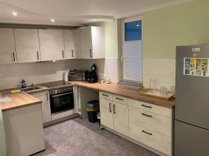 a kitchen with white cabinets and a refrigerator at Eliz Appartements in Ringsheim
