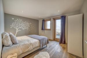 a bedroom with a bed with a tree mural on the wall at Chalet face au Mont-blanc in Sallanches
