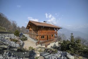 a large wooden cabin on a hill with mountains in the background at Chalet face au Mont-blanc in Sallanches