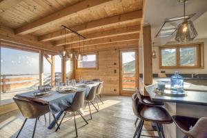 un comedor con una mesa larga y sillas en Chalet face au Mont-blanc, en Sallanches