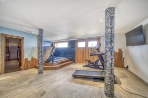 a room with a gym with a treadmill and a television at Chalet face au Mont-blanc in Sallanches