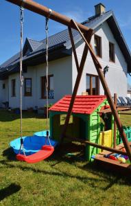 eine Schaukel vor einem Haus in der Unterkunft Pensjonat Wiktoria Mielenko in Mielenko