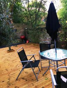 a patio with a table and chairs and an umbrella at One bedroom with garden in London