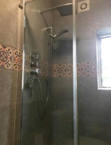 a shower with a glass door in a bathroom at One bedroom with garden in London