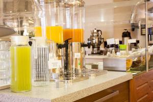 un mostrador con botellas de zumo de naranja en la cocina en Trip Inn Hotel Ariane, en Colonia