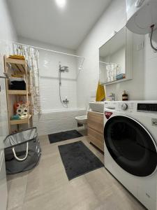 a white bathroom with a washing machine in it at Kej Garden - Two bedroom apartment. in Novi Sad