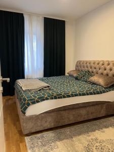 uma cama grande num quarto com cortinas pretas em Kej Garden - Two bedroom apartment. em Novi Sad