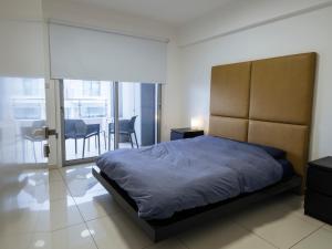 a bedroom with a large bed and a balcony at Chapo Central in Nicosia
