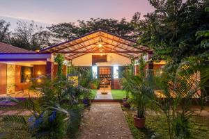 une maison avec une pergola dans la cour dans l'établissement Nihita I Yoga, Spa, retreat, à Dod Ballāpur