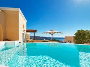 una piscina con sombrilla y el océano en Archipel Mansion, en Fira