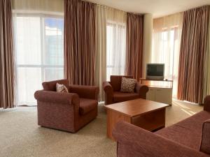 sala de estar con 2 sillas y TV en Helios Spa Hotel - All Inclusive - Pool & Children Slides - Entertainment, en Golden Sands